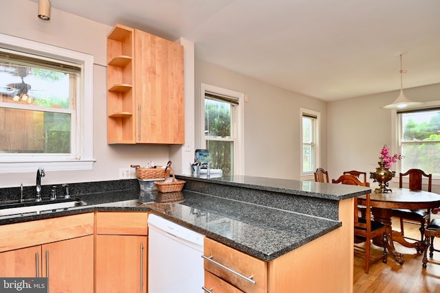 kitchen with light wood-type flooring, hanging light fixtures, dishwasher, sink, and kitchen peninsula