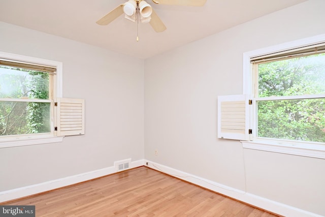 unfurnished room featuring hardwood / wood-style floors, ceiling fan, and a healthy amount of sunlight