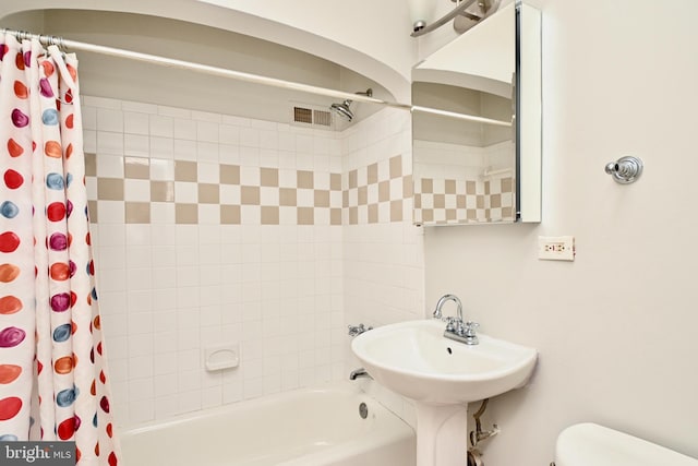 bathroom featuring shower / bath combination with curtain and toilet