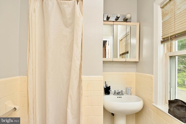 bathroom with sink, tile walls, and decorative backsplash