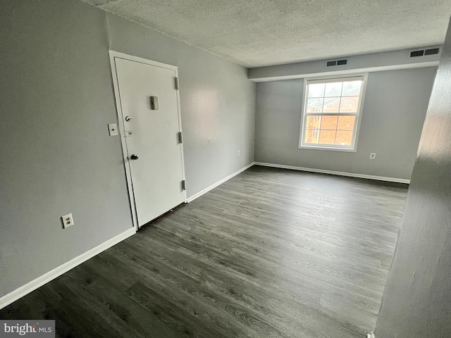 empty room featuring a textured ceiling and hardwood / wood-style floors