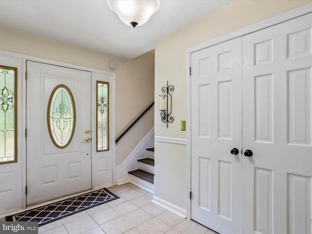 foyer with light tile patterned flooring and stairway