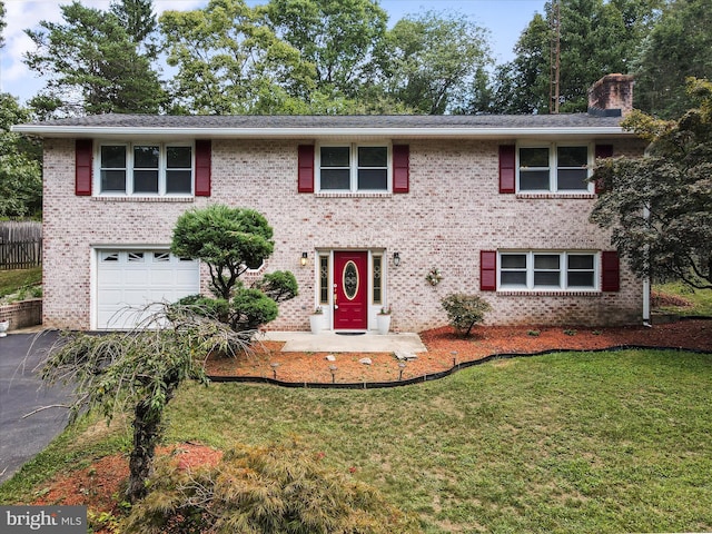 view of front facade featuring an attached garage, a front yard, a chimney, and brick siding