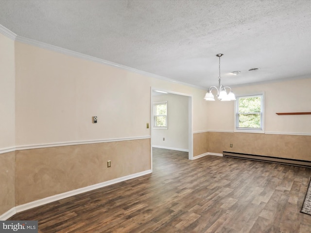 unfurnished room with a baseboard heating unit, a wealth of natural light, a textured ceiling, and wood finished floors