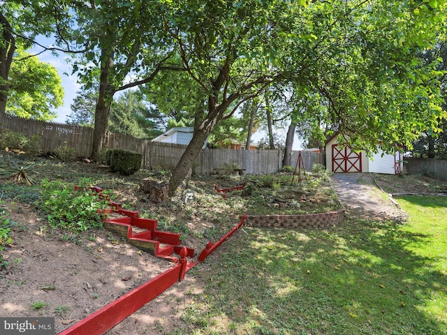 view of yard featuring a shed, a fenced backyard, and an outdoor structure