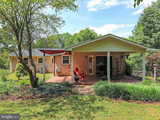 rear view of property featuring brick siding, fence, and a patio