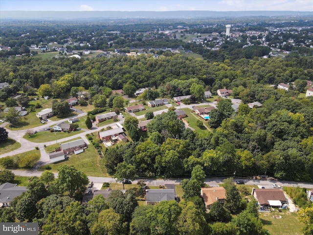 drone / aerial view featuring a residential view and a forest view