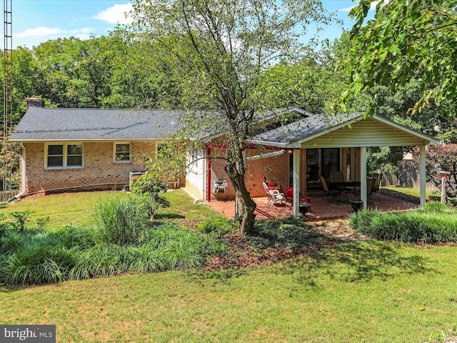 exterior space with a patio area, brick siding, a yard, and roof with shingles