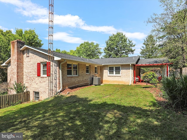 view of front of house with brick siding, a chimney, a front yard, central AC, and fence