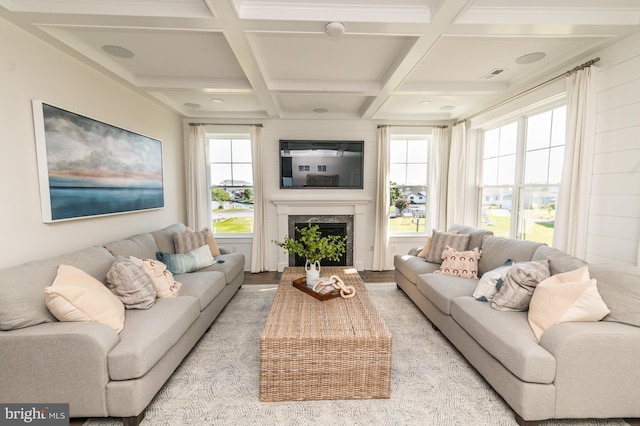 living room featuring light hardwood / wood-style flooring, coffered ceiling, beam ceiling, a fireplace, and crown molding