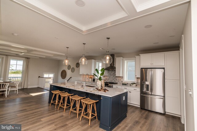 kitchen with white cabinets, a center island with sink, dark wood-type flooring, and stainless steel appliances