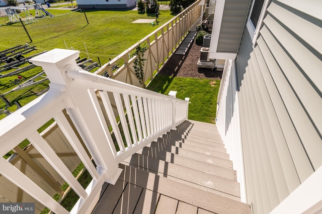 wooden deck featuring central AC and a lawn