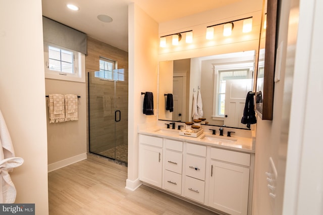 bathroom with a shower with door and vanity