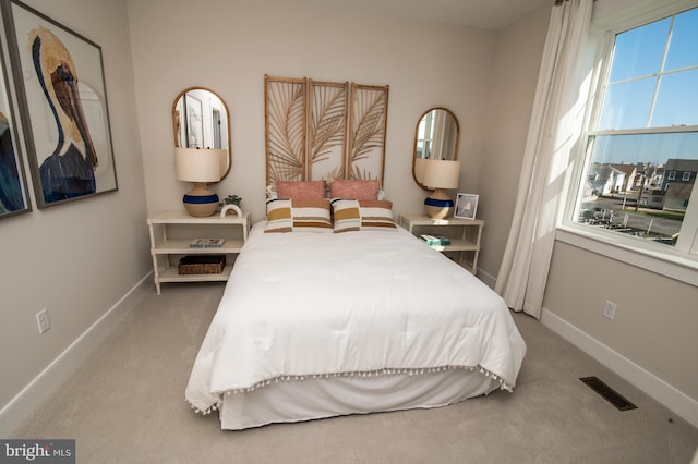 carpeted bedroom with visible vents and baseboards