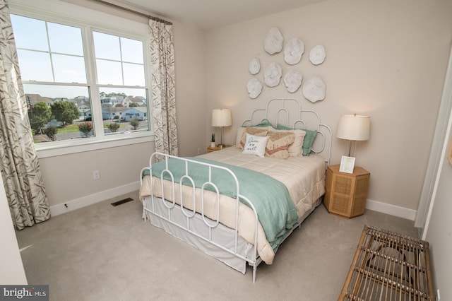 bedroom featuring visible vents, light carpet, and baseboards