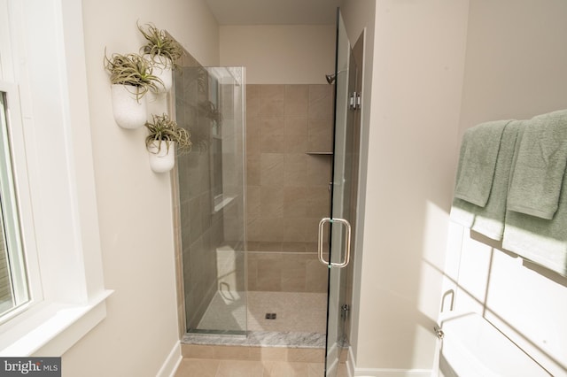 bathroom featuring a shower stall and baseboards