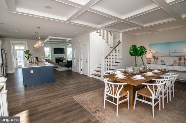 dining room featuring dark hardwood / wood-style flooring, an inviting chandelier, and coffered ceiling