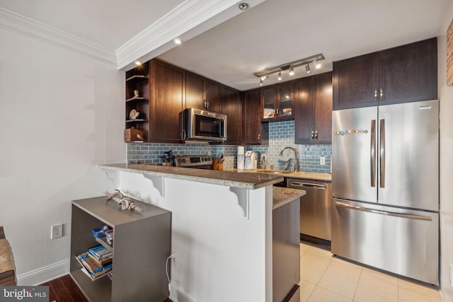 kitchen featuring kitchen peninsula, a kitchen breakfast bar, appliances with stainless steel finishes, and decorative backsplash