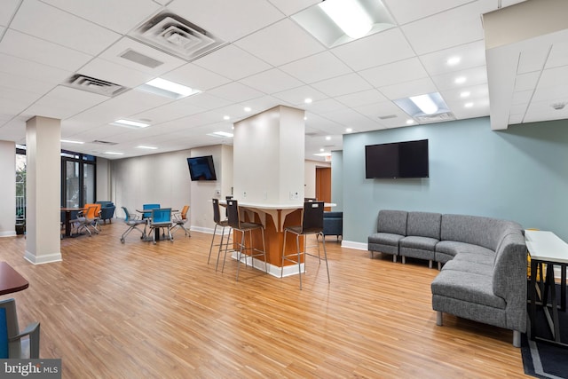 living room featuring light wood-type flooring, visible vents, and baseboards