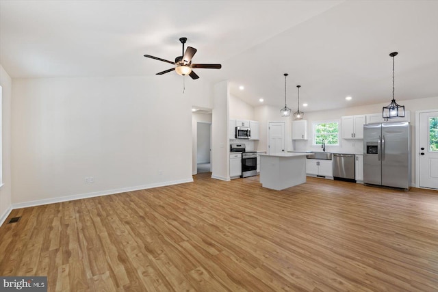 unfurnished living room with lofted ceiling, light hardwood / wood-style flooring, ceiling fan, and sink