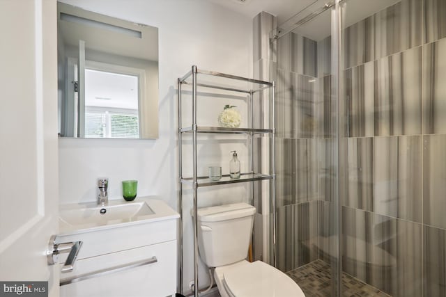 bathroom featuring vanity, toilet, and a shower with door