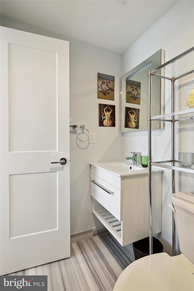 bathroom featuring vanity, toilet, and hardwood / wood-style flooring