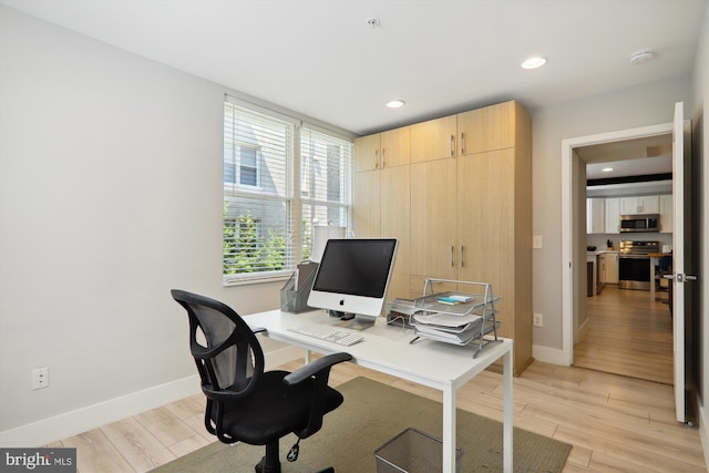 home office with light hardwood / wood-style floors