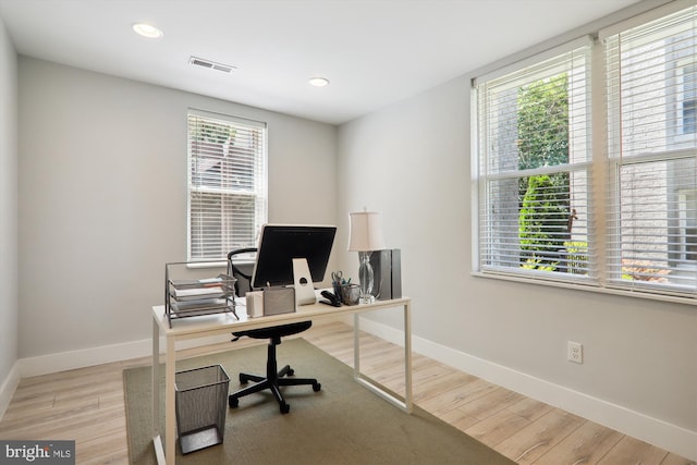 office featuring light wood-type flooring, baseboards, and visible vents