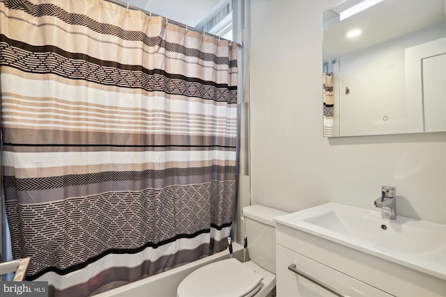 bathroom with shower / bath combo, vanity, and toilet