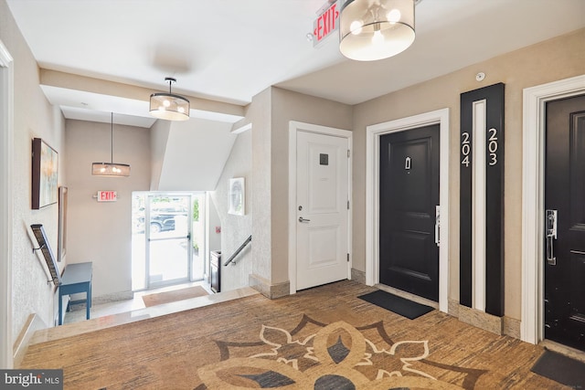 foyer featuring baseboards and wood finished floors