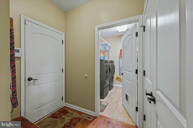 washroom with washing machine and dryer and light tile patterned flooring