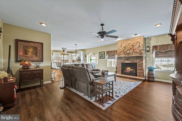 living room with a fireplace, ceiling fan, and dark hardwood / wood-style flooring