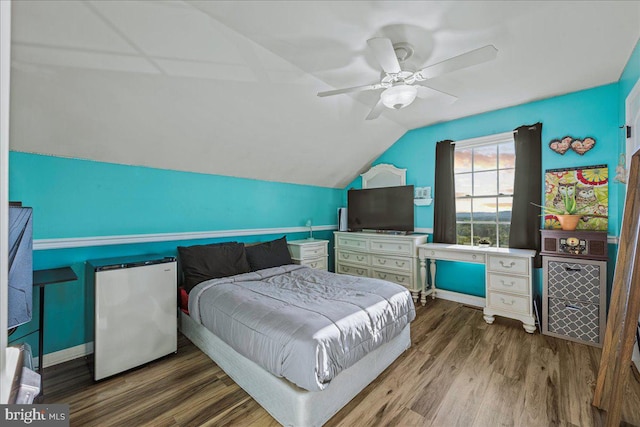 bedroom featuring hardwood / wood-style flooring, refrigerator, lofted ceiling, and ceiling fan