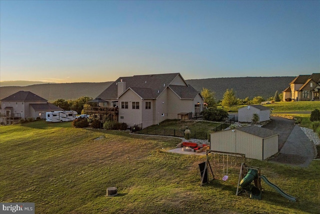 exterior space featuring a storage shed, a playground, and a yard