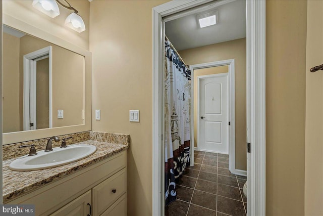 bathroom with toilet, tile patterned flooring, and vanity