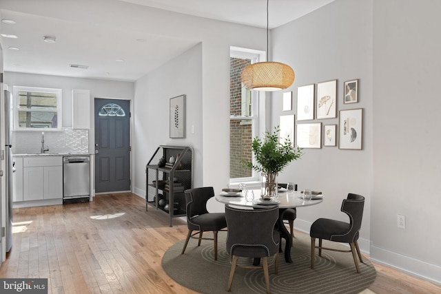 dining space featuring light hardwood / wood-style flooring and sink