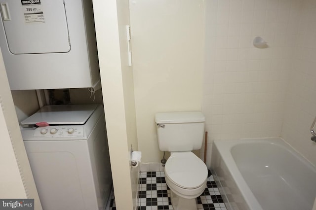 bathroom featuring toilet, stacked washer / drying machine, shower / bath combination, and tile patterned floors