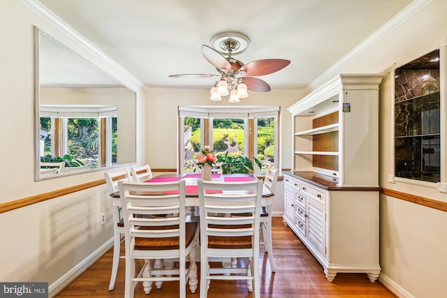 dining space with ceiling fan, hardwood / wood-style flooring, ornamental molding, and a healthy amount of sunlight