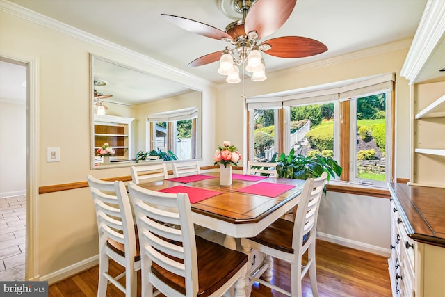 dining space with ceiling fan, crown molding, and light hardwood / wood-style floors