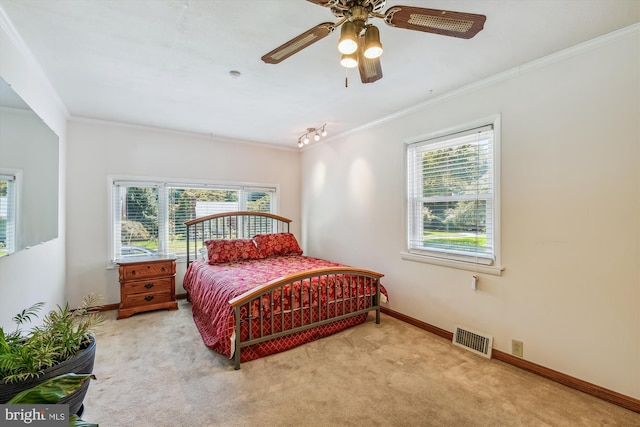 bedroom with light carpet, crown molding, visible vents, and baseboards