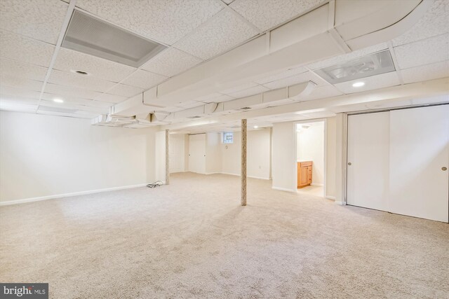 basement with carpet floors and a drop ceiling