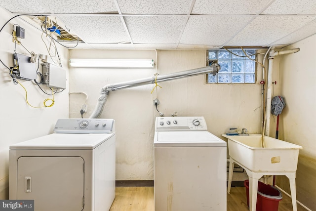 clothes washing area with laundry area, separate washer and dryer, and light wood-style floors