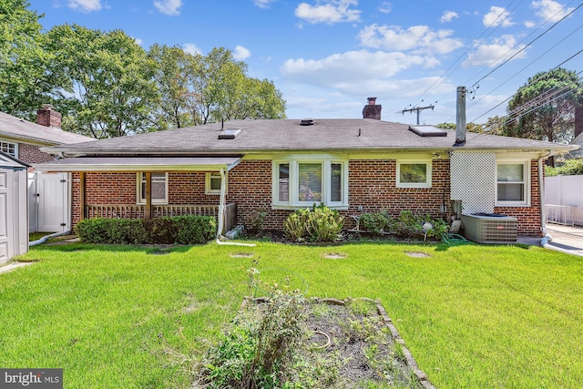 view of front of house featuring central AC, brick siding, a chimney, and a front lawn