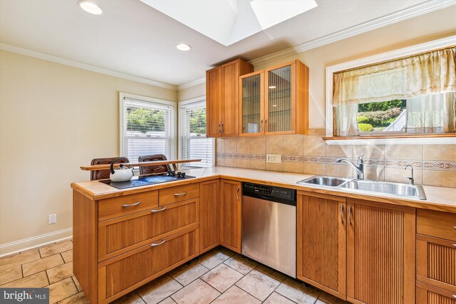 kitchen with backsplash, dishwasher, light tile patterned floors, and a skylight