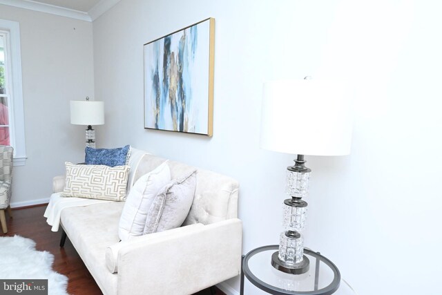 living area with baseboards, dark wood finished floors, and crown molding