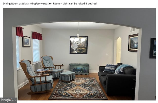 living room featuring hardwood / wood-style flooring and an inviting chandelier