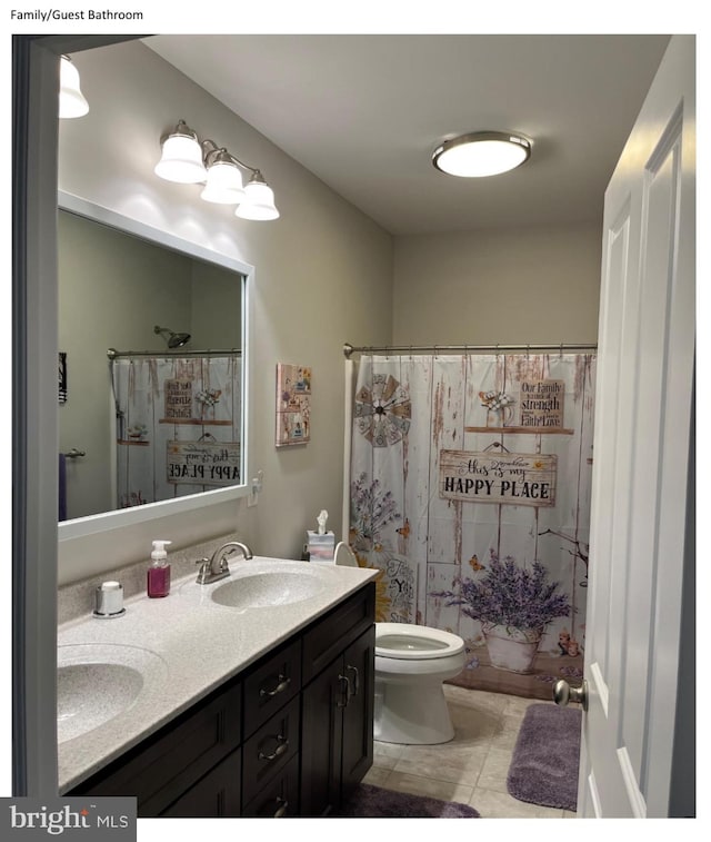 bathroom featuring vanity, toilet, tile patterned floors, and a shower with curtain