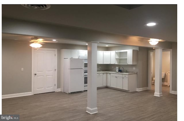 kitchen featuring ceiling fan, white cabinetry, stainless steel range oven, dark wood-type flooring, and white fridge