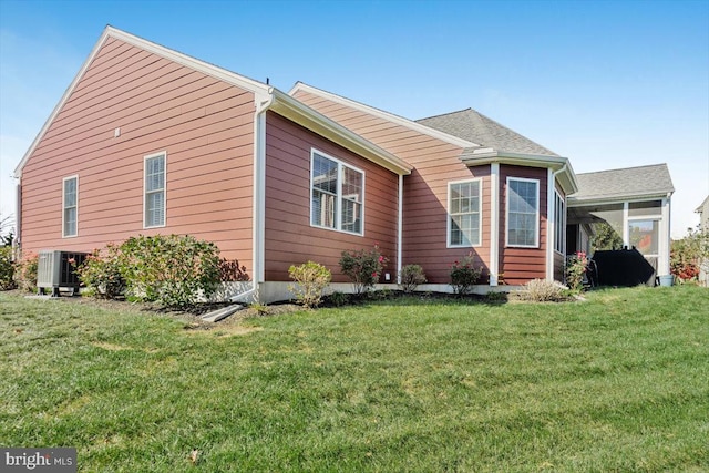 view of side of property with a yard, central AC unit, and a sunroom