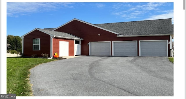 ranch-style house featuring a front yard and a garage